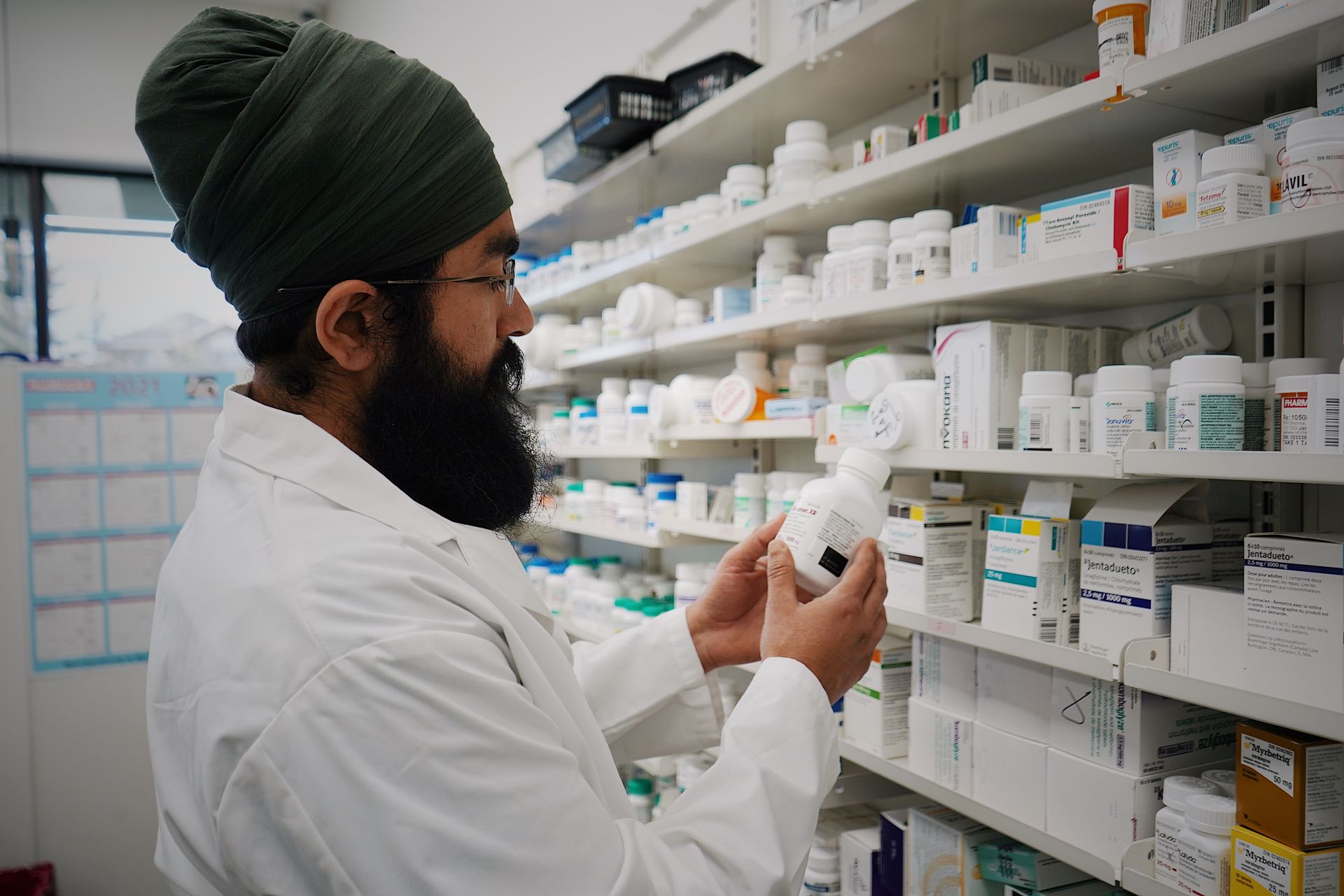 Un pharmacien devant les rayons de son officine